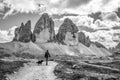 A female person hiking lonely with her dog around the Drei Zinnen mountains, the Dolomites in South Tirol