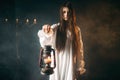Female person holds kerosene lamp, dark magic