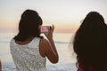 Female Person Taking Cell Phone Picture of the Beautiful Ocean Horizon at Sunset