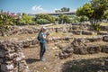 Female person visits Ancient Agora in Athens, Greece. Young pretty woman photographs classical Greek ruins in Athens city center