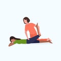 Female personal trainer doing stretching exercises with african american girl fitness instructor helping woman to Royalty Free Stock Photo