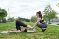 Female personal trainer helping young man to stretch his back and legs. Royalty Free Stock Photo