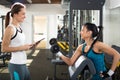 Female personal trainer helping young woman on her work out routines in gym Royalty Free Stock Photo