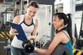 Female personal trainer helping young woman on her work out routines in gym. Royalty Free Stock Photo