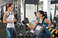 Female personal trainer helping young woman on her work out routines in gym Royalty Free Stock Photo