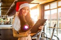 Female personal trainer with Santa hat holding clipboard at gym. Royalty Free Stock Photo