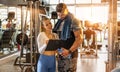 Female personal trainer showing exercise progress to male client in the gym. Royalty Free Stock Photo