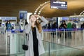 Female peson talking by smartphone and looking for friend at aiport. Royalty Free Stock Photo