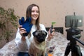 Female pet blogger. Woman recording video review of grooming products for dogs on her phone