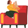 Female pet owner sitting and playing with cat in armchair. Girl with kitten spends time at home Royalty Free Stock Photo