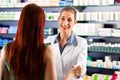 Female pharmacist in her pharmacy with a client Royalty Free Stock Photo