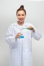 A female pharmacist mixing chemical liquids on medical scales in a laboratory