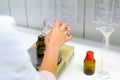 Female pharmacist mixing chemical liquids on medical scales in a laboratory Royalty Free Stock Photo
