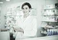 Female pharmacist noting assortment of drugs