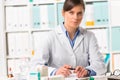 Female pharmacist sat at desk writing notes Royalty Free Stock Photo