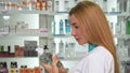 Female pharmacist smiling to the camera, holding two medication bottles Royalty Free Stock Photo