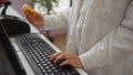 A female pharmacist in a white coat types on a keyboard while holding a medication bottle in a pharmacy setting Royalty Free Stock Photo