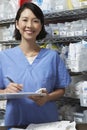 Female Pharmacist Writing On Clipboard Royalty Free Stock Photo