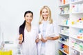 female pharmacists with digital tablet and medication smiling at camera