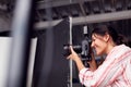 Female Photographer With Camera On Photo Shoot Against White Studio Backdrop Royalty Free Stock Photo