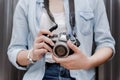 Female photographer holding mirrorless digital camera in her hands.Teenager carrying small camera for travel Royalty Free Stock Photo