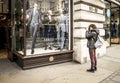 Female photographer photographs a man`s clothing store in Oxford street, London