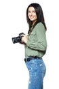 Female photographer reporter in jeans and a khaki shirt posing with a camera. Isolated on white