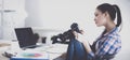 Female photographer sitting on the desk with laptop Royalty Free Stock Photo