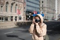 Female photographer taking a candid shot of a busy street with her Nikon FG 20 camera Royalty Free Stock Photo