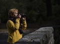 Female photographer in morning light looking over the top of the camera Royalty Free Stock Photo