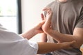 Female physical therapists help male patients with wrist injuries in a rehabilitation center. Physical therapy concepts