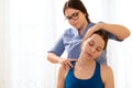 Female physiotherapist or a chiropractor adjusting patients neck. Physiotherapy, rehabilitation concept. White background.