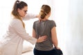 Female physiotherapist or a chiropractor examining patients back. Physiotherapy, rehabilitation concept.