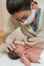 Female physiotherapist performing an evaluation of the maxillary in a newborn baby.