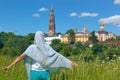 Female pilgrim in the green meadow in front of the orthodox monastery Royalty Free Stock Photo