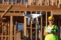 Female Pilot Flies Drone Quadcopter Inspecting Construction Site Royalty Free Stock Photo