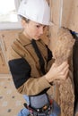 Female plasterer installing material on wall