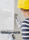 Female plasterer repairs wall