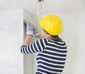 Female plasterer repairs wall