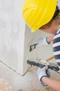 Female plasterer repairs wall