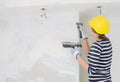 Female plasterer repairs wall