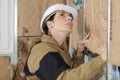 Female plasterer worker at indoors wall insulation works