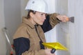 Female plasterer working on interior wall