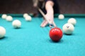 Female player ready to hit red ball on blue pool table Royalty Free Stock Photo