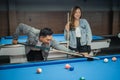 female player watching the male player poking the white ball Royalty Free Stock Photo