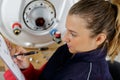 female plumber checking boiler Royalty Free Stock Photo
