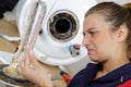 female plumber finding rust inside boiler