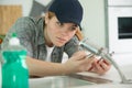 female plumber fitting tap in kichen sink Royalty Free Stock Photo