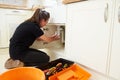 Female plumber fixing a kitchen sink Royalty Free Stock Photo