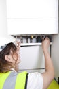 Female plumber servicing central heating boiler Royalty Free Stock Photo